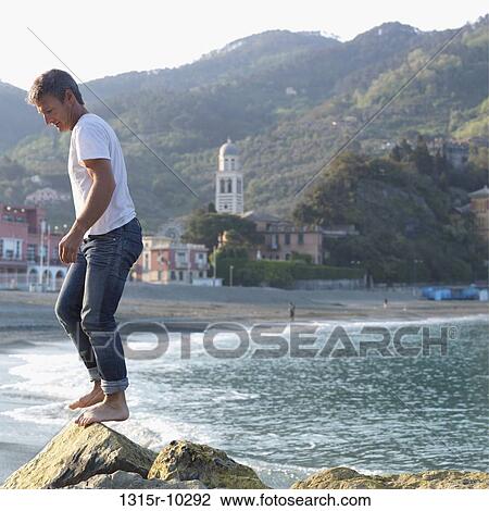 Italy, Liguria, Levanto, Man balances on rocks above beach/sea View Large Photo Image Stock Image - Italy, Liguria, Levanto, Man balances on rocks above beach/sea. Fotosearch