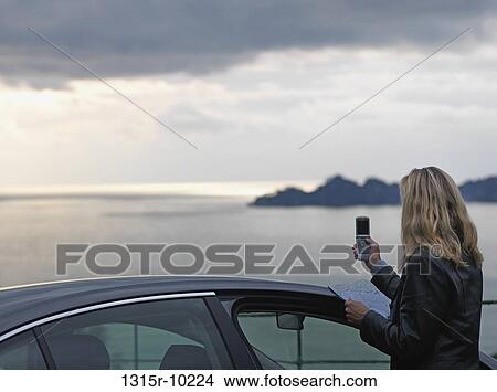 Italy, Liguria, Portofino, Woman sending text message by car, above shimmering sea View Large Photo Image Picture - Italy, Liguria, Portofino, Woman sending text message by car, above shimmering sea. Fotosearch
