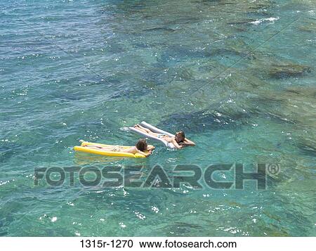 Italy, Liguria, Teenage girls floating on calm waters of Mediterranean Sea View Large Photo Image Stock Image - Italy, Liguria, Teenage girls floating on calm waters of Mediterranean Sea. Fotosearch