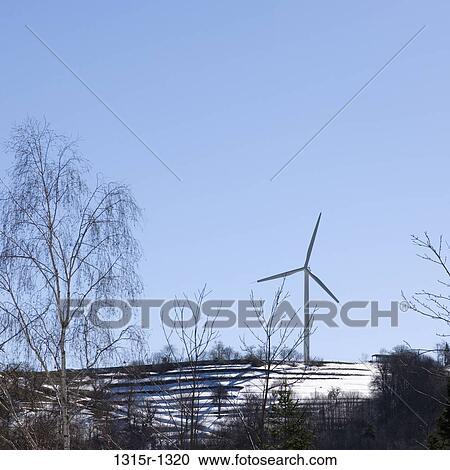 Stock Image - Italy, Liguria, wind turbine above snow covered farm terrace. Fotosearch