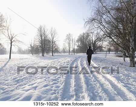 Italy, Man walking along car track through fresh snow on winter day View Large Photo Image Stock Image - Italy, Man walking along car track through fresh snow on winter day. Fotosearch