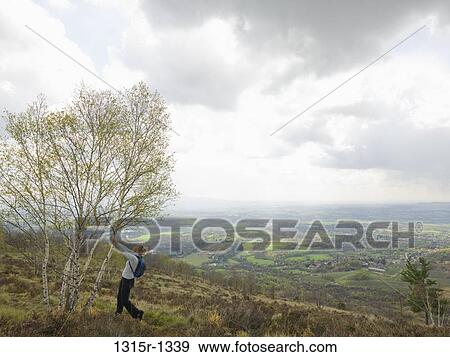Italy, Piedmont, backpacker stretching against tree in countryside View Large Photo Image Stock Photo - Italy, Piedmont, backpacker stretching against tree in countryside. Fotosearch