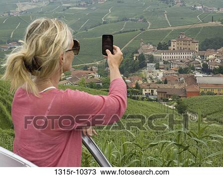 Italy, Piedmont, Barolo, Woman photographing townscape with camera phone View Large Photo Image Stock Image - Italy, Piedmont, Barolo, Woman photographing townscape with camera phone. Fotosearch