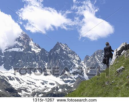 Italy, Piedmont, Businessman walking through mountain meadow and looking up View Large Photo Image Stock Photo - Italy, Piedmont, Businessman walking through mountain meadow and looking up. Fotosearch