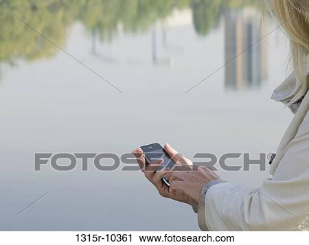 Italy, Piedmont, Close-up of woman sending text messaging by river reflection View Large Photo Image Stock Image - Italy, Piedmont, Close-up of woman sending text messaging by river reflection. Fotosearch