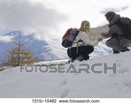 Italy, Piedmont, Couple examining map in snowy mountain meadow View Large Photo Image Stock Image - Italy, Piedmont, Couple examining map in snowy mountain meadow. Fotosearch