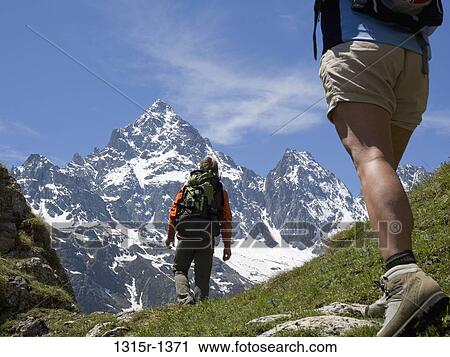 Italy, Piedmont, Couple hiking across meadow to distant mountain View Large Photo Image Stock Image - Italy, Piedmont, Couple hiking across meadow to distant mountain. Fotosearch