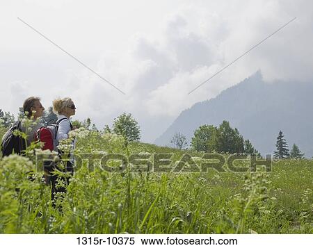 Italy, Piedmont, Couple in meadow of wildflowers looking at mountains View Large Photo Image Stock Photography - Italy, Piedmont, Couple in meadow of wildflowers looking at mountains. Fotosearch