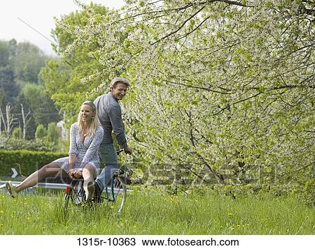 Italy, Piedmont, Couple riding cruiser bike through meadow View Large Photo Image Stock Image - Italy, Piedmont, Couple riding cruiser bike through meadow. Fotosearch