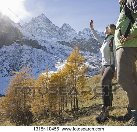 Italy, Piedmont, Couple taking cell phone picture of snowcapped mountains View Large Photo Image Stock Photograph - Italy, Piedmont, Couple taking cell phone picture of snowcapped mountains. Fotosearch