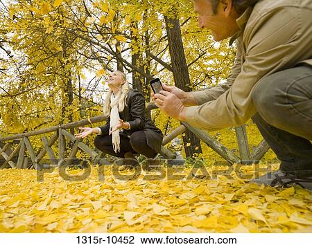 Italy, Piedmont, Couple taking pictures of autumn leaves View Large Photo Image Stock Image - Italy, Piedmont, Couple taking pictures of autumn leaves. Fotosearch