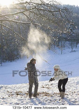 Italy, Piedmont, Couple throwing snow overhead in snowy park View Large Photo Image Stock Photo - Italy, Piedmont, Couple throwing snow overhead in snowy park. Fotosearch