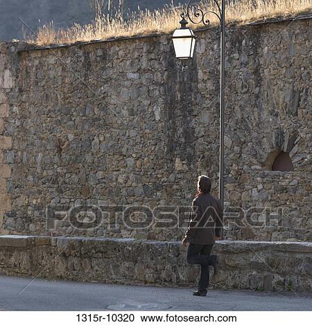Italy, Piedmont, Cuneo, Man walking beside medieval wall View Large Photo Image Stock Image - Italy, Piedmont, Cuneo, Man walking beside medieval wall. Fotosearch