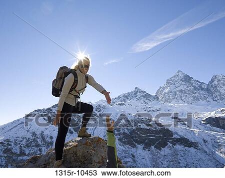 Italy, Piedmont, Female mountaineer offering help to companion View Large Photo Image Stock Image - Italy, Piedmont, Female mountaineer offering help to companion. Fotosearch
