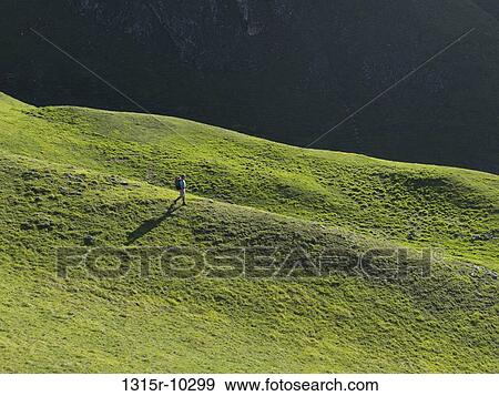 Italy, Piedmont, Hiker descends green mountain meadow View Large Photo Image Stock Photo - Italy, Piedmont, Hiker descends green mountain meadow. Fotosearch