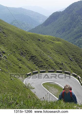 Italy, Piedmont, Hiker walking up green mountain slope above road View Large Photo Image Stock Photograph - Italy, Piedmont, Hiker walking up green mountain slope above road. Fotosearch