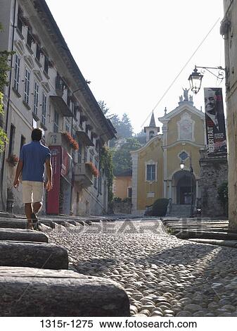 Italy, Piedmont, Lake Orta, Orta, man walking up cobblestone street View Large Photo Image Stock Photography - Italy, Piedmont, Lake Orta, Orta, man walking up cobblestone street. Fotosearch