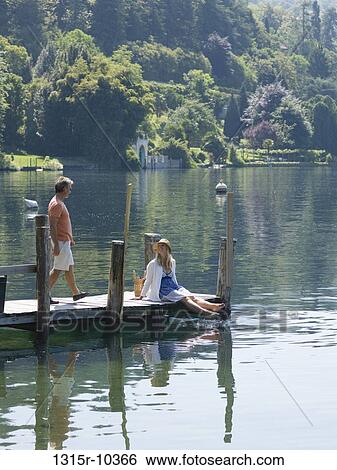 Italy, Piedmont, Man and woman on wooden pier at in Lake Orta View Large Photo Image Stock Photograph - Italy, Piedmont, Man and woman on wooden pier at in Lake Orta. Fotosearch