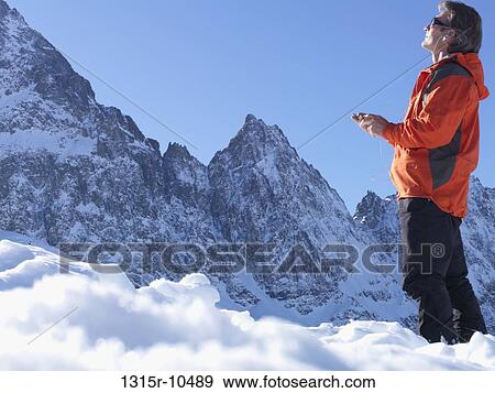Italy, Piedmont, Man listening to mp3 player in mountain landscape in Winter View Large Photo Image Stock Photo - Italy, Piedmont, Man listening to mp3 player in mountain landscape in Winter. Fotosearch