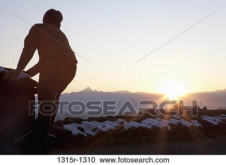 Italy, Piedmont, man watching sunset from snowy rooftop View Large Photo Image Stock Image - Italy, Piedmont, man watching sunset from snowy rooftop. Fotosearch