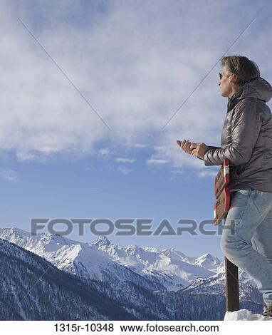 Italy, Piedmont, Man with mobile phone looking at mountains View Large Photo Image Stock Photo - Italy, Piedmont, Man with mobile phone looking at mountains. Fotosearch