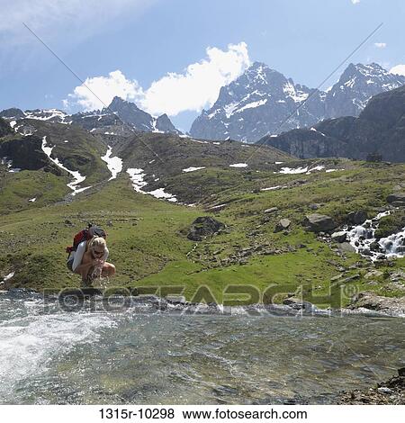 Italy, Piedmont, MonteViso, Hiker scoops clean water from mountain stream View Large Photo Image Stock Photo - Italy, Piedmont, MonteViso, Hiker scoops clean water from mountain stream. Fotosearch