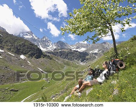 Italy, Piedmont, MonteViso, Hikers relax in green mountain meadow View Large Photo Image Stock Image - Italy, Piedmont, MonteViso, Hikers relax in green mountain meadow. Fotosearch