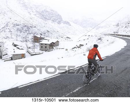 Italy, Piedmont, Mountain biker cycling up snowy mountain road View Large Photo Image Stock Image - Italy, Piedmont, Mountain biker cycling up snowy mountain road. Fotosearch