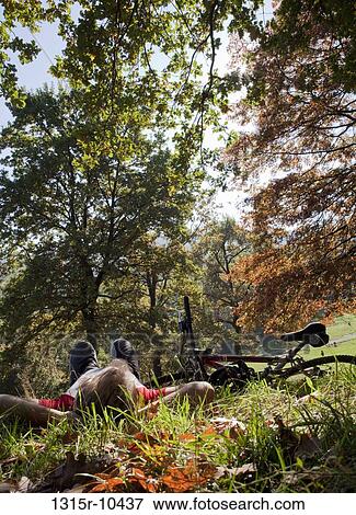Italy, Piedmont, Mountain biker resting in park View Large Photo Image Stock Photo - Italy, Piedmont, Mountain biker resting in park. Fotosearch