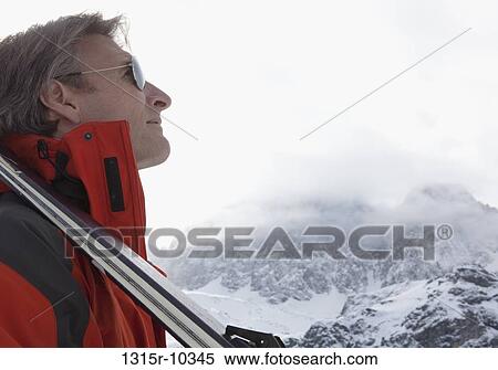 Italy, Piedmont, Portrait of skier looking up into mountains View Large Photo Image Stock Photography - Italy, Piedmont, Portrait of skier looking up into mountains. Fotosearch