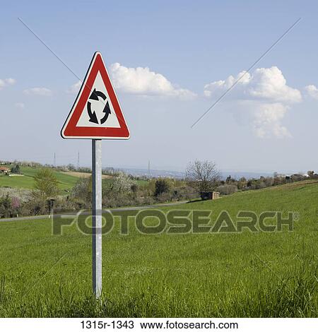 Stock Image - Italy, Piedmont, roundabout sign in meadow. Fotosearch