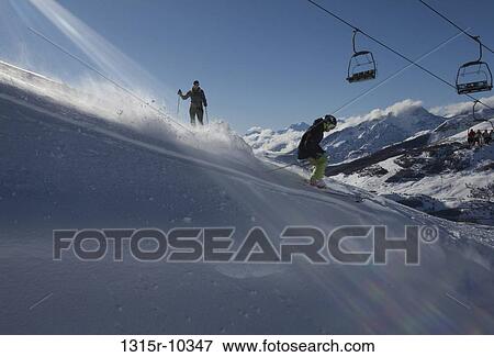 Stock Photo - Italy, Piedmont, Sestriere, Teenage boy skiing down slope below chairlift. Fotosearch