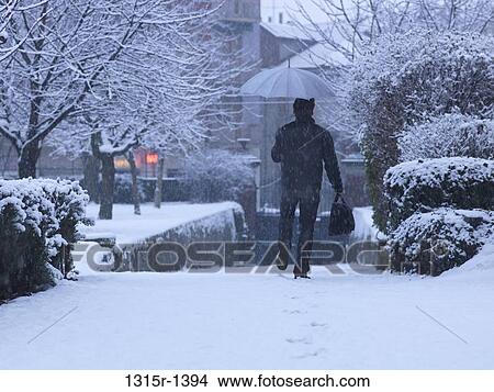 Italy, Piedmont, Turin, businessman setting off to work on foot on snowy winter's day View Large Photo Image Picture - Italy, Piedmont, Turin, businessman setting off to work on foot on snowy winter's day. Fotosearch
