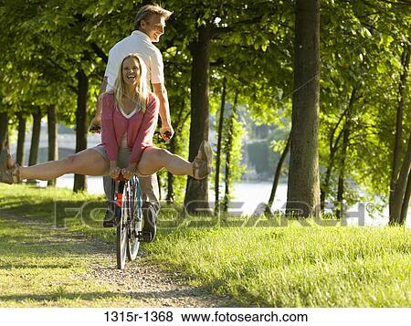 Italy, Piedmont, Turin, Couple on bicycle in park View Large Photo Image Stock Photo - Italy, Piedmont, Turin, Couple on bicycle in park. Fotosearch