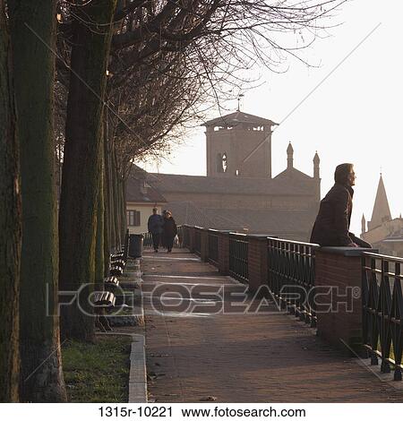 Italy, Piedmont, Turin, Man sitting on railing and looking at medieval town View Large Photo Image Stock Image - Italy, Piedmont, Turin, Man sitting on railing and looking at medieval town. Fotosearch