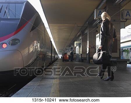 Stock Image - Italy, Piedmont, Turin, Woman approaching Eurostar high speed train. Fotosearch