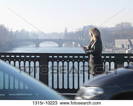 Italy, Piedmont, Turin, Woman walking across bridge sending text message View Large Photo Image Stock Image - Italy, Piedmont, Turin, Woman walking across bridge sending text message. Fotosearch