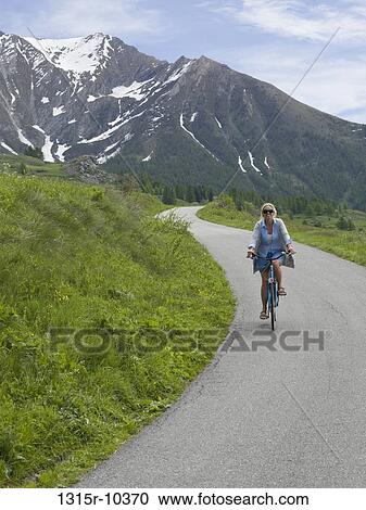Italy, Piedmont, Woman cycling down mountain road View Large Photo Image Stock Image - Italy, Piedmont, Woman cycling down mountain road. Fotosearch