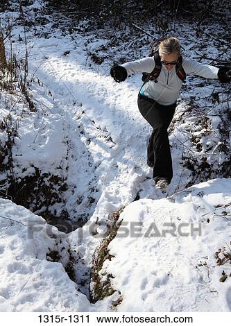 Italy, Piedmont, woman jumping above snowy gap on forest walk View Large Photo Image Stock Image - Italy, Piedmont, woman jumping above snowy gap on forest walk. Fotosearch