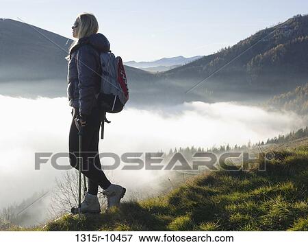 Italy, Piedmont, Woman looking at mountains from meadow above fog View Large Photo Image Stock Photo - Italy, Piedmont, Woman looking at mountains from meadow above fog. Fotosearch