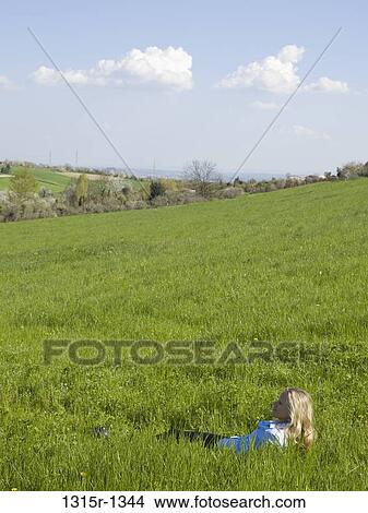 Italy, Piedmont, woman lying in grass in countryside View Large Photo Image Picture - Italy, Piedmont, woman lying in grass in countryside. Fotosearch