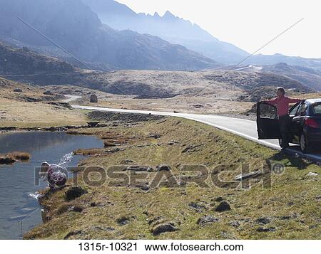 Italy, Piedmont, Woman splashing in mountain lake, man waiting View Large Photo Image Stock Image - Italy, Piedmont, Woman splashing in mountain lake, man waiting. Fotosearch