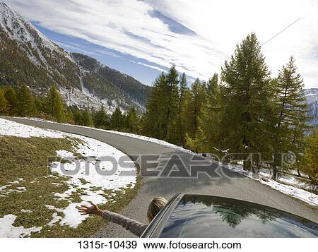Italy, Piedmont, woman stretching arm out car window in mountains View Large Photo Image Stock Photo - Italy, Piedmont, woman stretching arm out car window in mountains. Fotosearch