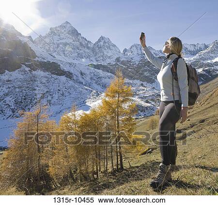 Italy, Piedmont, Woman taking cell phone picture of snowcapped mountains View Large Photo Image Stock Photography - Italy, Piedmont, Woman taking cell phone picture of snowcapped mountains. Fotosearch