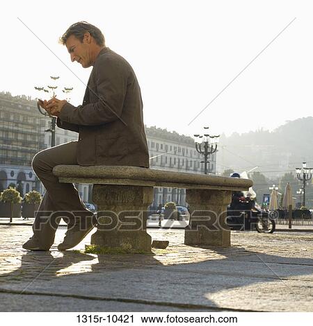 Italy, Turin, Man sending text message from bench in piazza View Large Photo Image Stock Image - Italy, Turin, Man sending text message from bench in piazza. Fotosearch