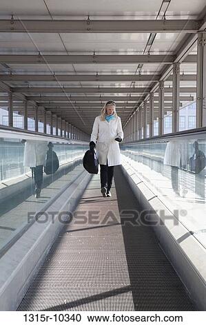 Italy, Turin, Woman checking text message on moving walkway View Large Photo Image Stock Image - Italy, Turin, Woman checking text message on moving walkway. Fotosearch
