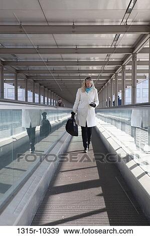 Italy, Turin, Woman checking text message on moving walkway View Large Photo Image Stock Photo - Italy, Turin, Woman checking text message on moving walkway. Fotosearch