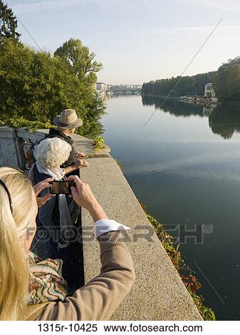 Italy, Turin, Woman taking cell phone picture of senior couple across Po River View Large Photo Image Stock Photography - Italy, Turin, Woman taking cell phone picture of senior couple across Po River. Fotosearch