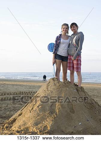 Italy, two teenage girls on heap of sand View Large Photo Image Stock Photo - Italy, two teenage girls on heap of sand. Fotosearch
