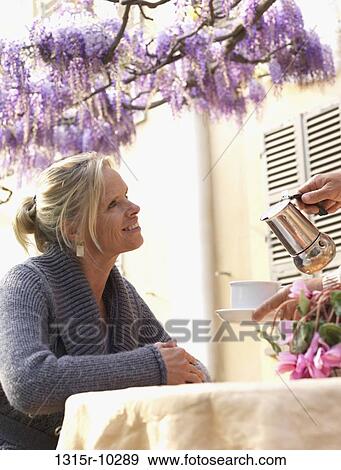 Italy, Wisteria blossoms in background man pours expresso for woman at outdoor table View Large Photo Image Stock Photo - Italy, Wisteria blossoms in background man pours expresso for woman at outdoor table. Fotosearch